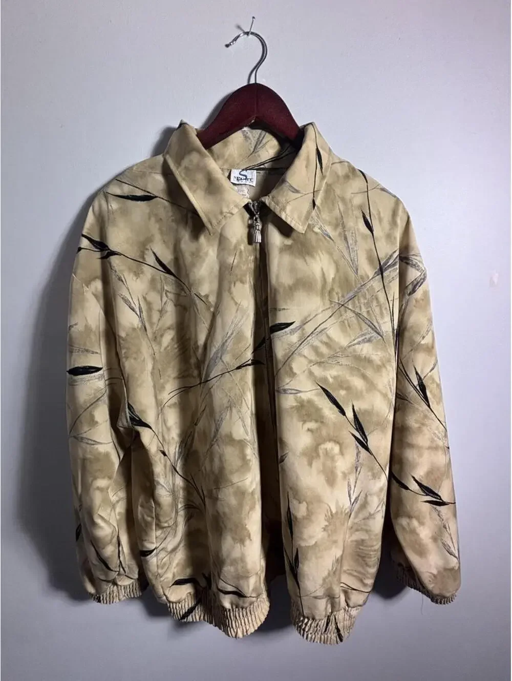 90s Sportswear Jacket with black leaf-like graphics on beige background